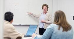 MBA director Tami Thompson in front of a class next to a whiteboard.